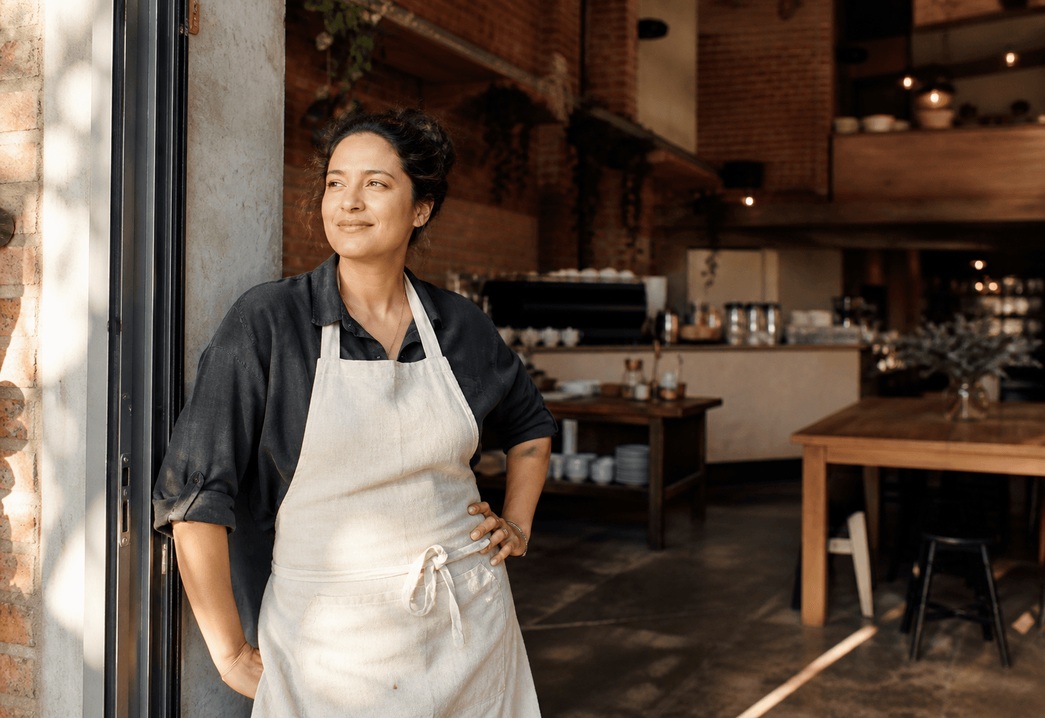 A small business owner standing in their café
